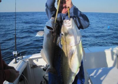 a person holding two fish